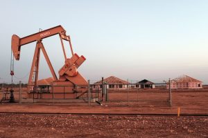 An oil well in Midland, Texas, idled by the world oil glut is juxtaposed against partially built homes caught in the oil bust. (Photo by Spencer Platt/Getty Images)
