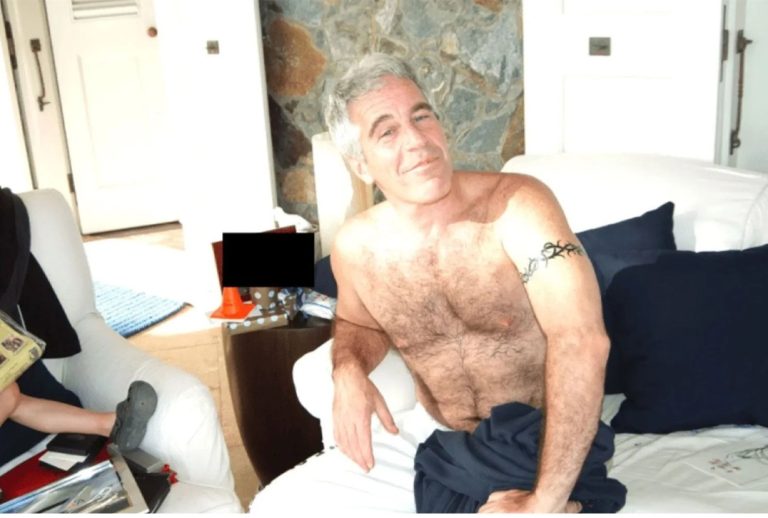 A shirtless Jeffrey Epstein sits on a bed. A young girl is off to his right. (Photo: DOJ)